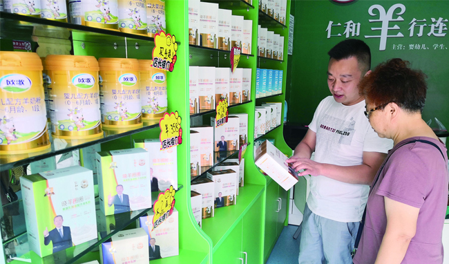 店主正在向顾客介绍羊奶粉.jpg